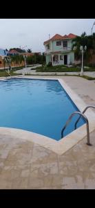 a large blue swimming pool in front of a house at Villas Guzmán in Constanza