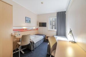 a hotel room with a bed and a table and chairs at Aparthotel Skylight Katowice by BookingHost in Katowice