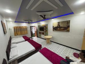 a room with two beds and a person sitting in it at Hotel Gopal-Krishna Palace in Ujjain