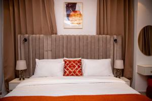 a bedroom with a large bed with two lamps at WHITNEY LUXURY APARTMENTs in Lekki
