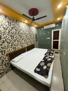 a bed in a room with a ceiling fan at Hotel Gopal-Krishna Palace in Ujjain +8 photos