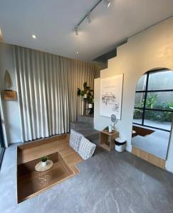 a living room with a table and a large window at Akaya Villas Solo in Kemiri