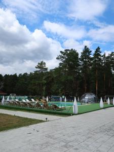 a green boat with tables and chairs in a park at Avenue Boutique Hotel in Borovoye