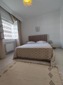 Un dormitorio con una cama y una lámpara de araña. en N17 Bis, en Dar el Ouzir