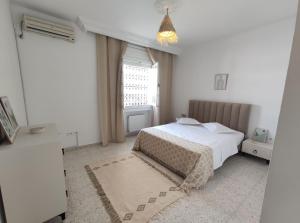 Un dormitorio blanco con una cama y una ventana. en N17 Bis, en Dar el Ouzir