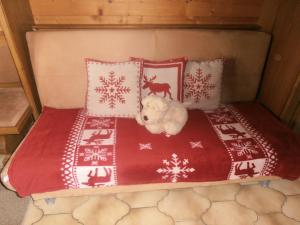 a stuffed teddy bear laying on a bed with pillows at Gästehaus Hölzlbauer in Krimml +3 photos