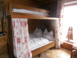 a bunk bed with white pillows in a room at Gästehaus Hölzlbauer in Krimml