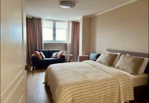 基希讷乌1-2 Bedrooms central with in house restaurant的一间卧室，里面有一张床、一把椅子和一扇窗户