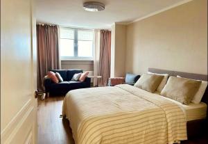 基希讷乌1-2 Bedrooms central with in house restaurant的一间卧室，里面有一张床、一把椅子和一扇窗户