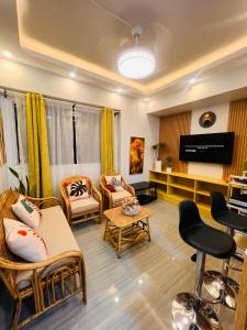 a living room with furniture and a flat screen tv at Mezza Residences in Manila