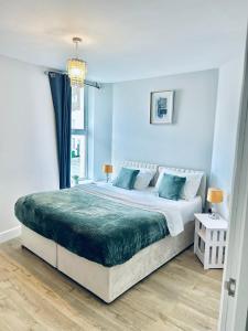 a bedroom with a large bed with blue walls at Folkestone Harbour Flat 2BR sleeps 4 in Folkestone