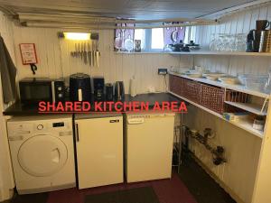 a kitchen with a washer and a washing machine at Private room with shared bathroom and kitchen in Ödkarby