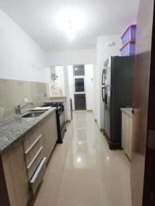 una cucina con frigorifero nero e pavimento bianco di Exclusive, Elegant Atlantis Comfortable a Santa Cruz de la Sierra