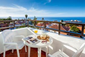 a balcony with a table and chairs and the ocean at Apartamentos Masaru in Puerto de la Cruz