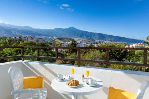 a table and chairs on a balcony with a view at Apartamentos Masaru in Puerto de la Cruz