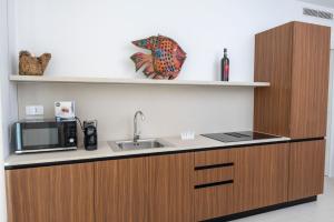 une cuisine avec un évier et un micro-ondes dans l'établissement Hotiday Apartments Giulianova, à Giulianova
