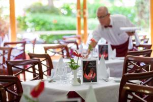 a man is preparing a table in a restaurant at Apartamentos Masaru in Puerto de la Cruz