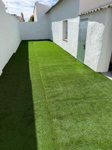 einen Hof mit grünem Gras neben einem weißen Gebäude in der Unterkunft La Paca 