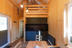 a kitchen in a tiny house with a wooden table at Tinyhouse Wald-Liesl in Neuwerk