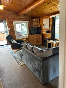 a living room with a couch and a tv at Happy Place LogCabin in Trawsfynydd