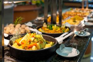 a buffet with many dishes of food on a table at Apartamentos Masaru in Puerto de la Cruz