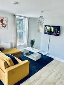 a living room with a couch and a tv at Folkestone Harbour Flat 2BR sleeps 4 in Folkestone