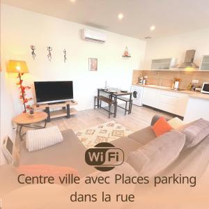 a living room with a couch and a kitchen at L'Ibéris - Toutes les commodités dans la rue - 1er étage in Auch