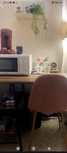 a microwave sitting on top of a table at loue chambre chez l'habitant in Saint-Victoret