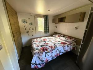a small bedroom with a bed and a window at Mobil home Premium super cosy entre Lac et Océan in Hourtin