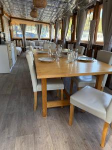 a dining room with a wooden table and chairs at Mobil home Premium super cosy entre Lac et Océan in Hourtin