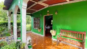 a green house with a bench and a table at Casa AnaMar in Moyogalpa