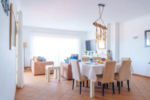 eine Küche und ein Esszimmer mit Tisch und Stühlen in der Unterkunft T3 Praia del Rey, piscina e vista mar, Óbidos, A7 in Óbidos