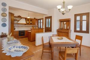 Una cocina y un comedor con mesa y sillas. en Mila House, en Mouresi