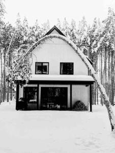 a house with an archway in the snow at Le Petit chalet au Lac Schryer in Lac-Simon