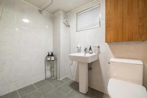 Un baño blanco con inodoro y lavabo. en New Dunchon Station 3 minutes KSPO DOME JYP Olympic Park Lotte World Asan Hospital Sungshim Hospital Free parking, en Seúl