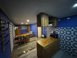 eine Küche und ein Esszimmer mit blauen Wänden und einem Tisch in der Unterkunft Aur House in Puerto Natales