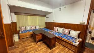 a room with two beds and a table in it at Tashi taksang homestay in Darjeeling