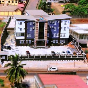 a blue building with a parking lot in a city at Padelia Hotels Ltd in Nsukka