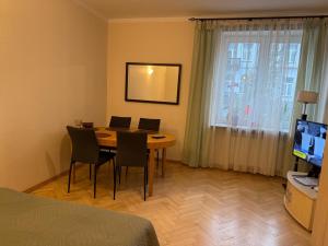 a room with a table and chairs and a television at Mieszkanie w Centrum in Białystok
