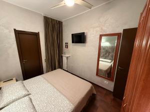 pokój hotelowy z łóżkiem i lustrem w obiekcie Casetta Cortese w mieście Opera