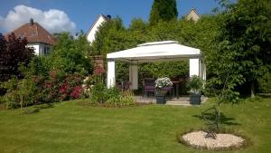 a white gazebo with a table in a yard at Haus Alexandra in Bad Driburg