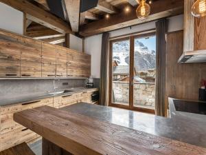a kitchen with a table and a view of a mountain at Appartement Duplex avec Terrasse, Jacuzzi et Cheminée - Val-d'Isère - FR-1-567-63 in Val dʼIsère +10 photos
