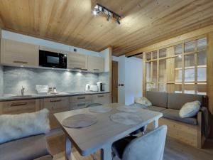 a kitchen and living room with a table and a couch at Appartement rénové au cœur de Val d'Isère - 1 chambre + coin montagne, balcon sud, parking inclus - FR-1-567-95 in Val dʼIsère
