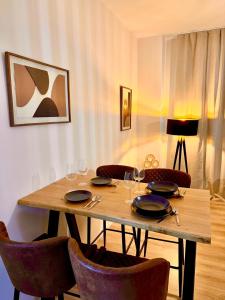 a wooden table with chairs and wine glasses at Ideale Stadtwohnung in Siegen in Siegen