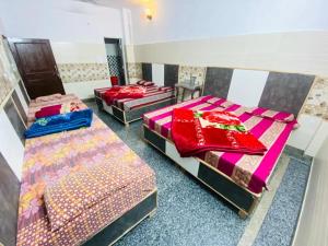 una habitación con tres camas en una habitación en Hotel Family Stay Near Shivmurti Chowk - A Group Hotel Of Ganga, en Haridwar