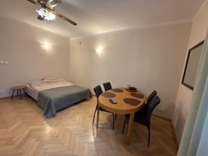 a bedroom with a bed and a table and chairs at Mieszkanie w Centrum in Białystok