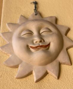 a plastic sun ornament with a smiling face on a wall at CityHouse Cagliari in Cagliari