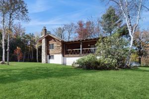 a small house in a field with a grass yard at Parker Lane Cabin in Weston