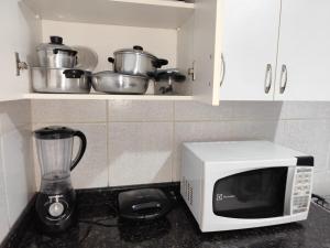 a kitchen counter with a microwave and a blender at Casa térrea no centro in Vitória da Conquista