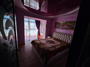 a bedroom with a bed in a purple room at Penthouse 15 floor in Kamianske
